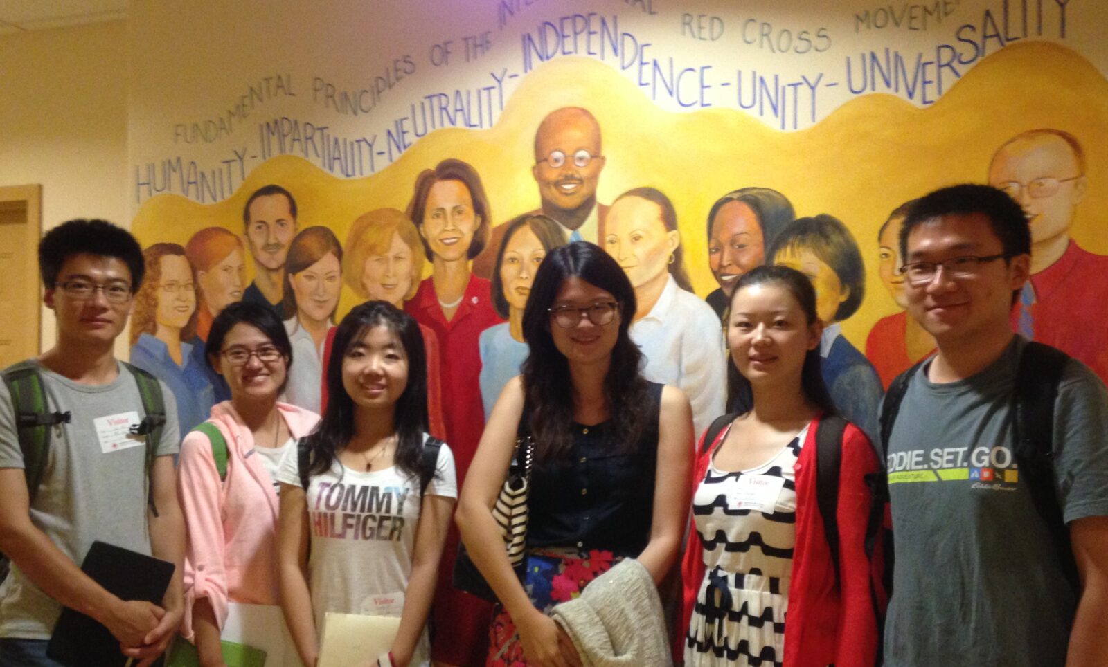 Bejing Normal University exchange students gather at the American Red Cross in front of a mural.