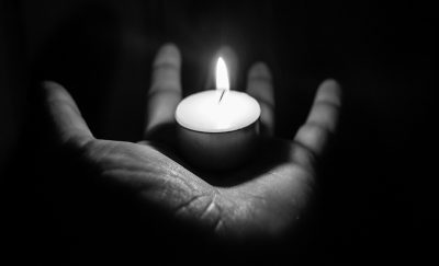 tea light reflecting on hand in the dark