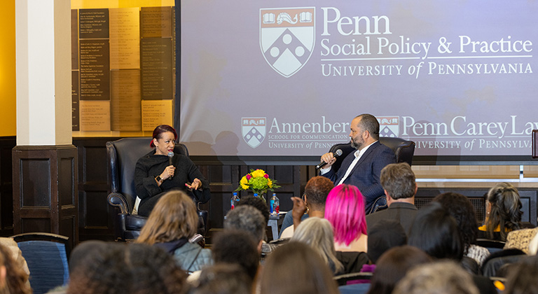 Nikole Hannah-Jones and Ben Jealous sit onstage before an audience. A blue screen behind them shows the logos of Penn's School of Social Policy & Practice, the Annenberg School, and Penn Carey Law.
