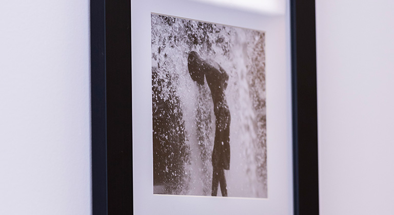 A black and white photo on a lobby wall shows a boy in a spray of water.