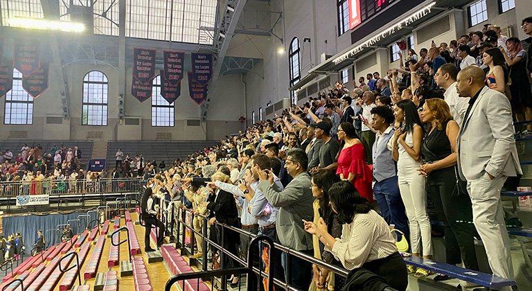 Audience members stand in the back section of the Palestra seating